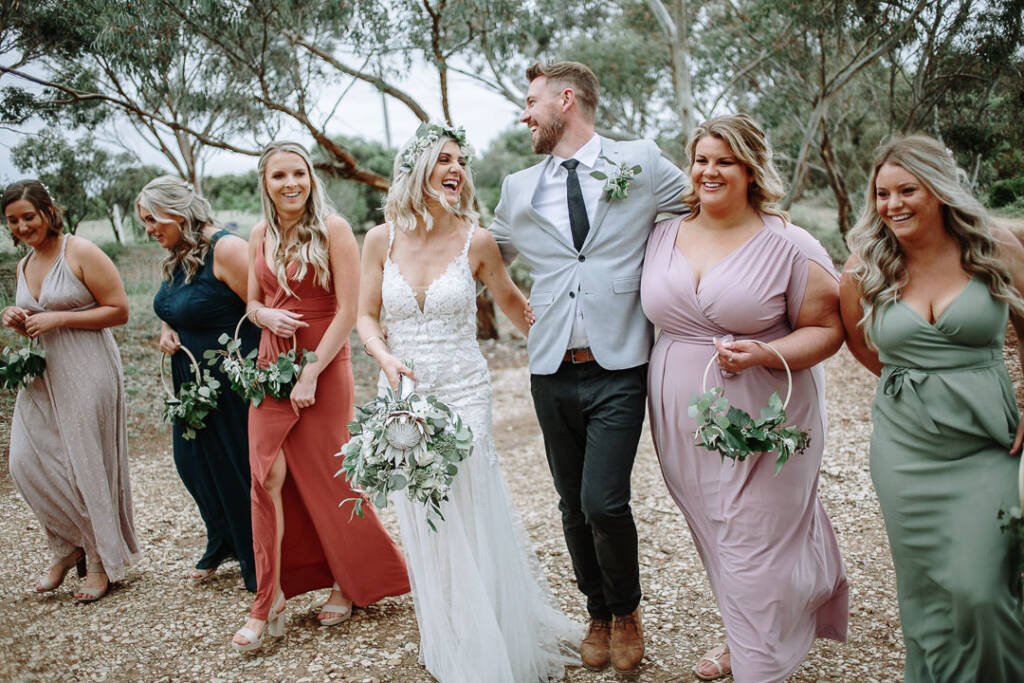 Kelly and Tory walk with their wedding attendants along a track at Camp Sunnystones.