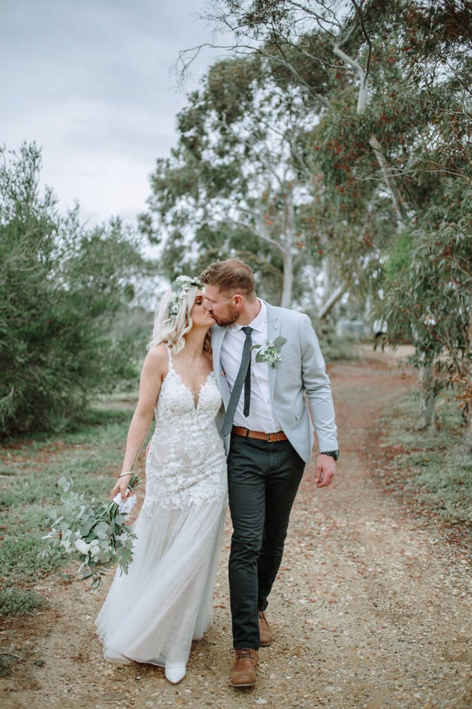 Kelly and Tory kiss while walking along a gravel track at Camp Sunnystones.