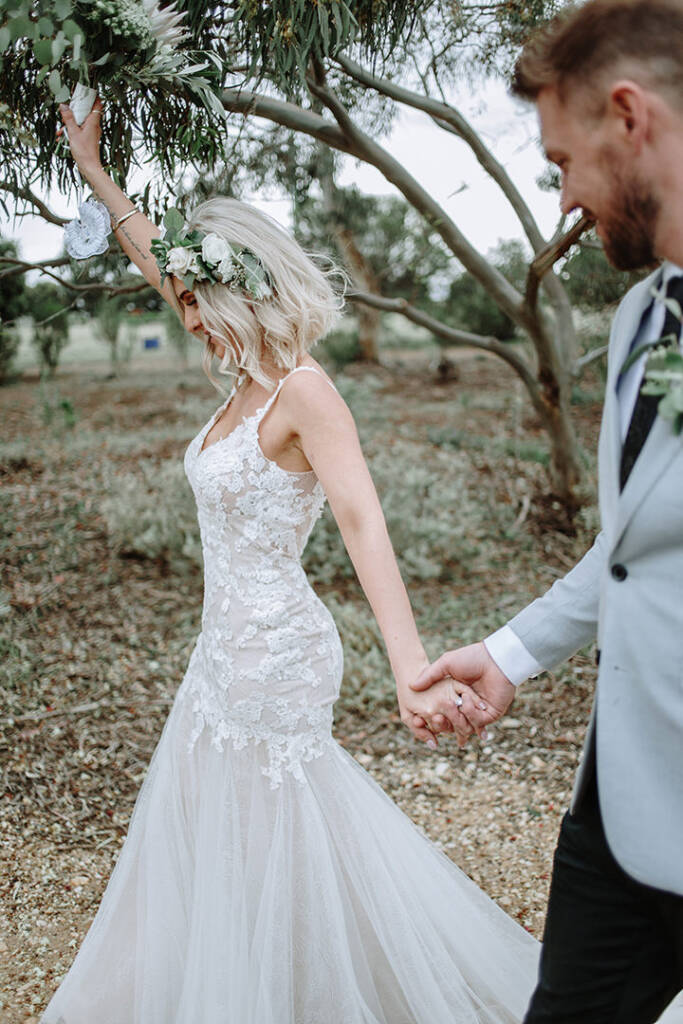 Kelly raises her bouquet above her head while holding Tory’s hand at Camp Sunnystones.