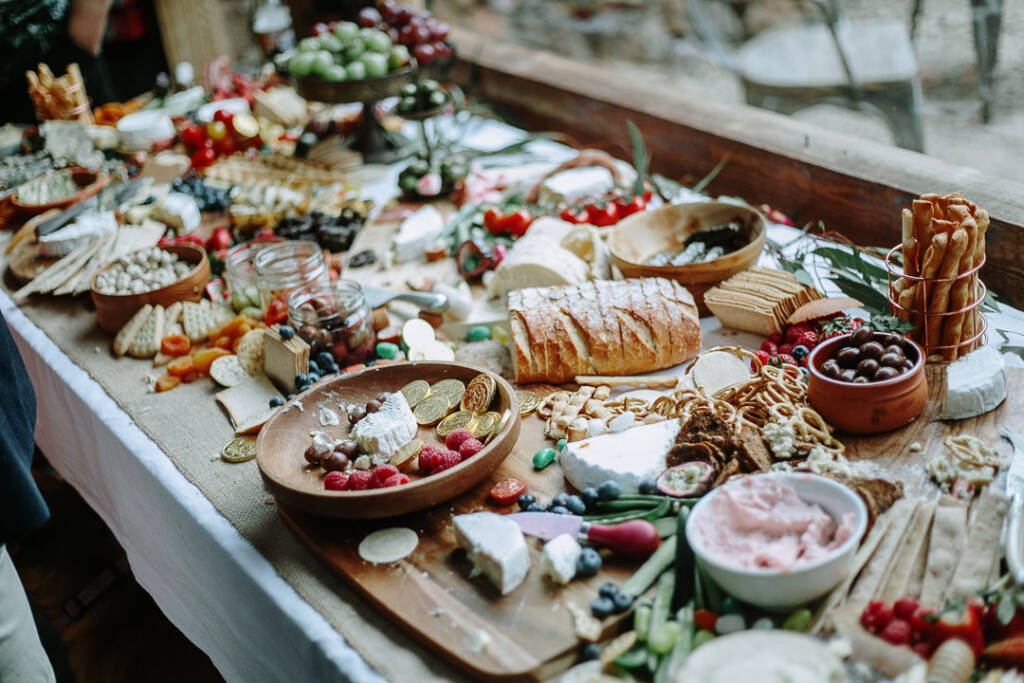 Cheese, bread, fruit and sweets fill the grazing table at Sunnystones’ country wedding reception.