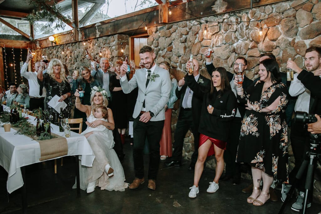 Guests raise bottles and glasses for a wedding toast at Camp Sunnystones.