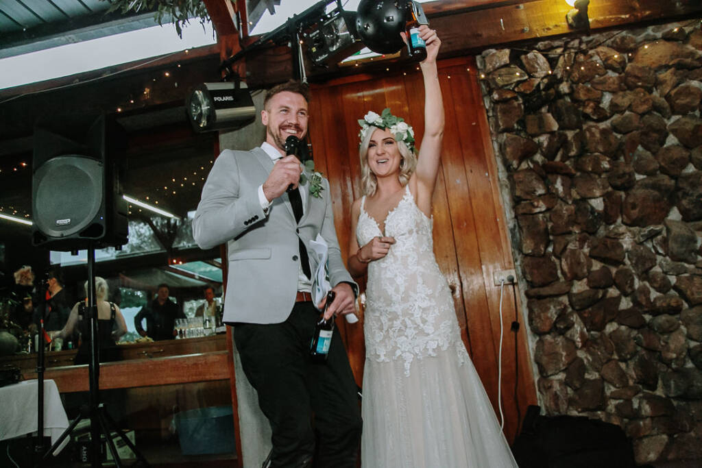 Kelly raises her beer bottle while Tory holds the microphone at Sunnystones.