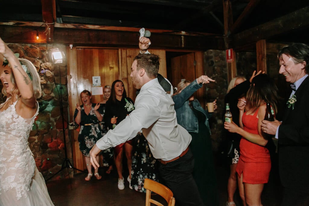 A guest raises an arm above the crowd on the Camp Sunnystones dance floor.