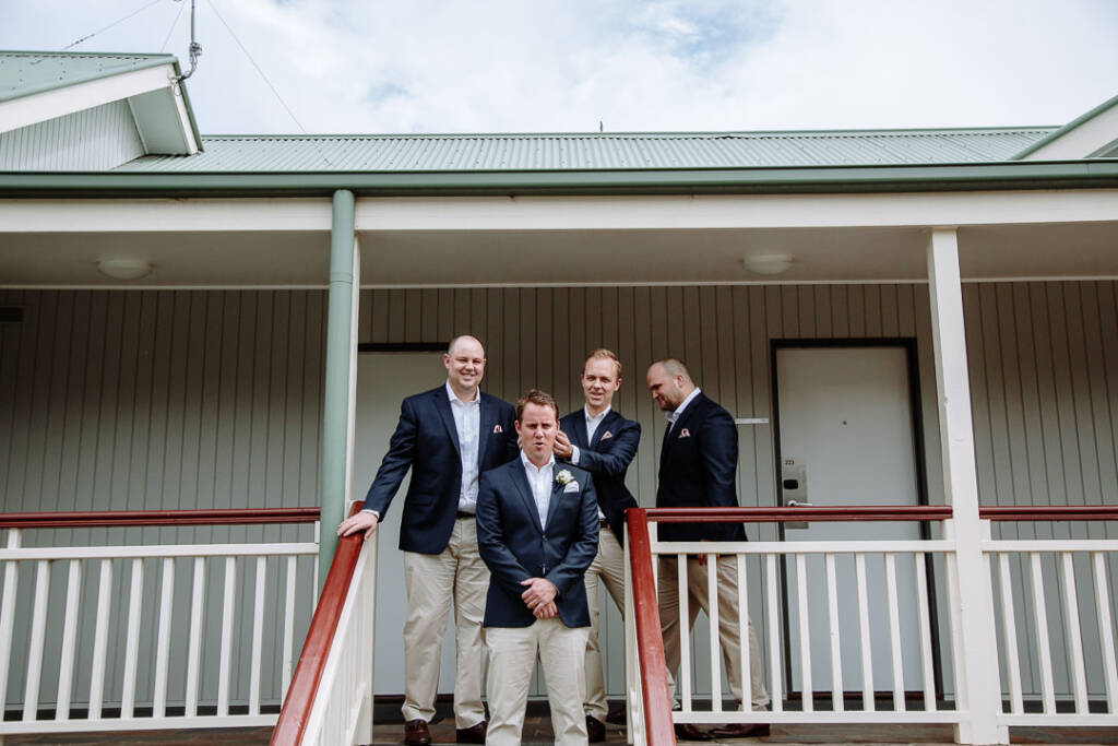 A groomsman ruffles Nick's hair on the outdoor steps at RACV Cape Schanck Resort.