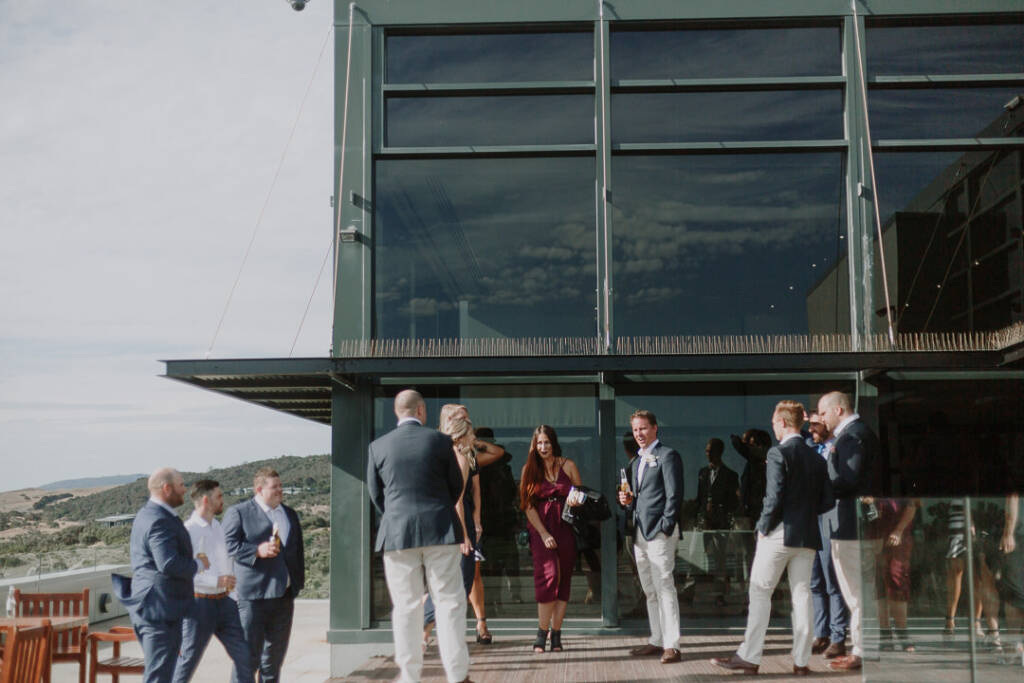Guests mingle on the deck outside The National's glass-fronted clubhouse in Cape Schanck.