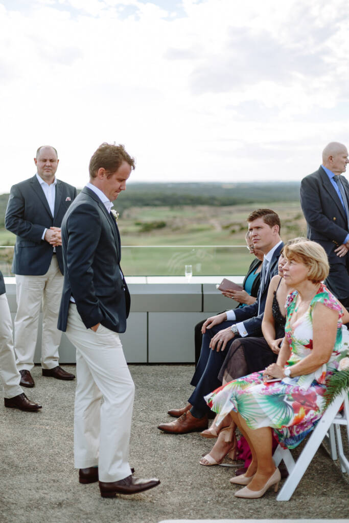 Nick passes seated guests beside The National's coastal golf links before the ceremony.
