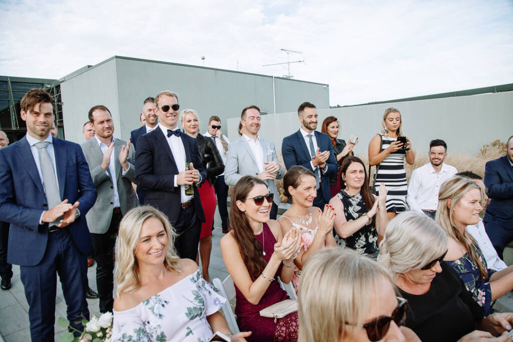 Guests applaud outside The National Golf Club's glass-fronted clubhouse.
