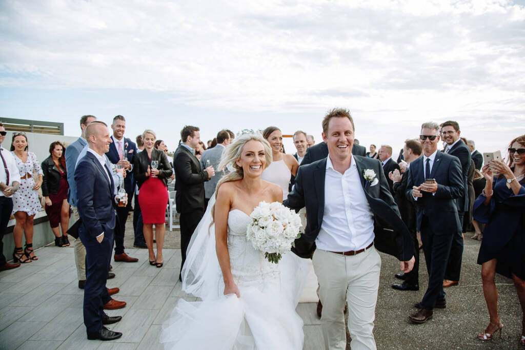Aasher and Nick walk back up The National Golf Club's ceremony aisle as guests applaud.