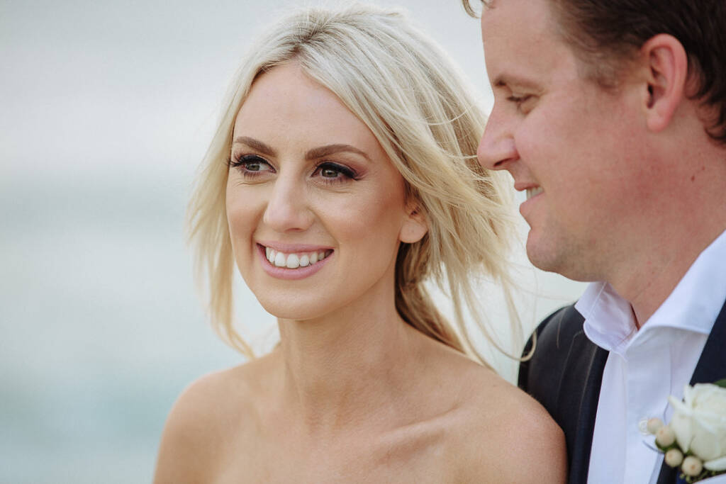 Wind blows Aasher's hair across her face as Nick stands beside her above Fingal Beach.