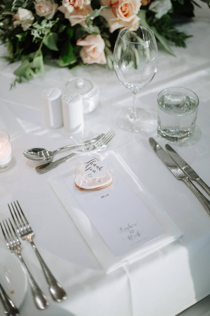 Nick's personalised menu and heart-shaped biscuit favour on a reception table at The National.