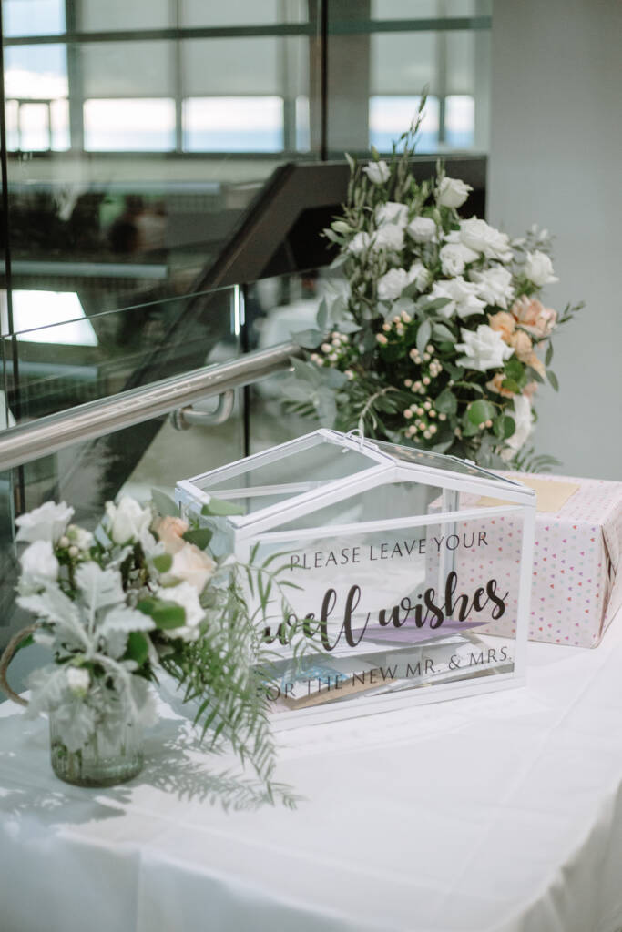Glass wishing well and white roses on the gift table at The National Golf Club.