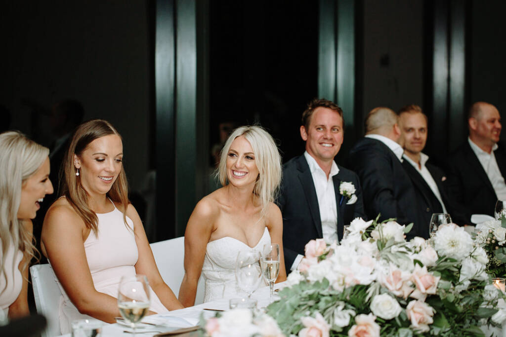 Aasher laughs at The National's bridal table as Nick grins beside her.