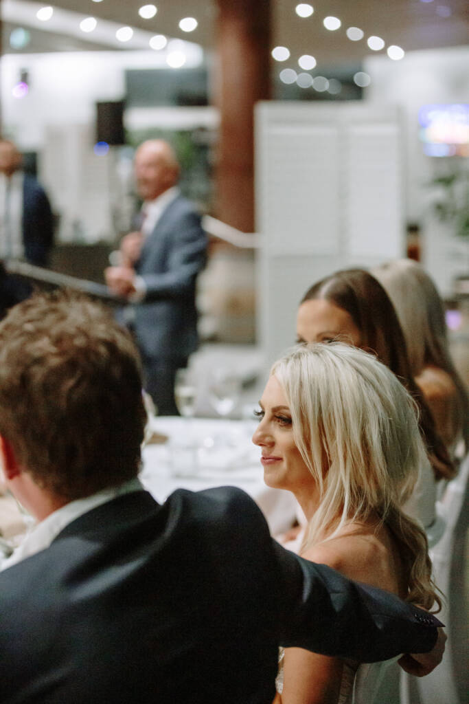 Aasher listens beside Nick beneath reception lights at The National Golf Club.