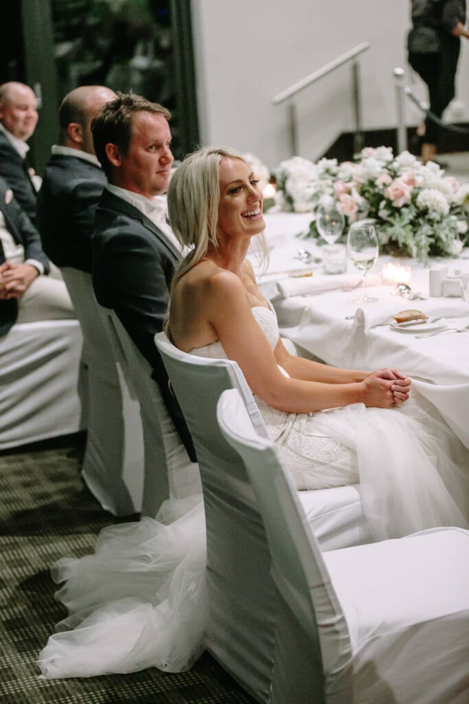 Aasher laughs at the head table inside The National's clubhouse, hands clasped.