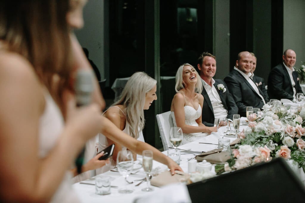 Aasher laughs at The National's bridal table during a bridesmaid's speech.