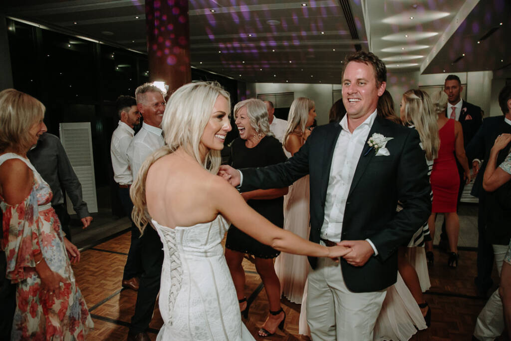 Aasher and Nick dance with guests under coloured party lights at The National Golf Club.
