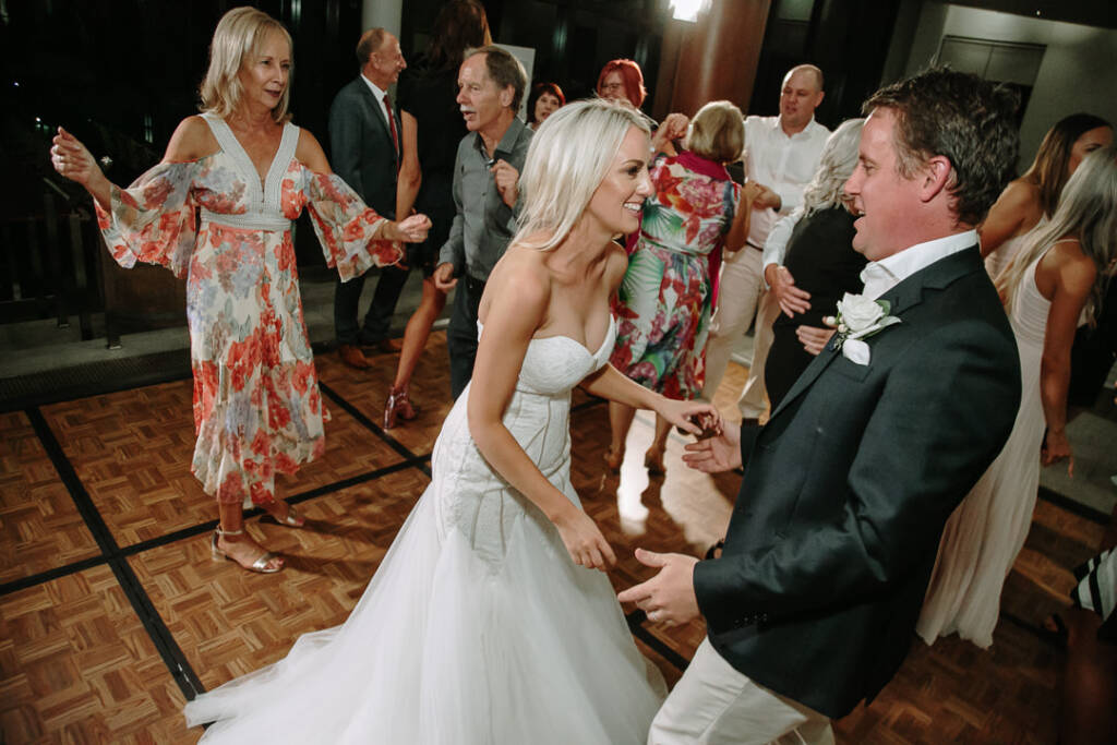 Aasher and Nick laugh together on The National's dance floor beside a guest in a floral dress.