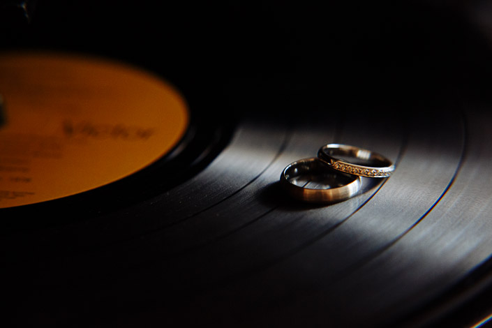 Two wedding rings rest on a vinyl record with an orange label.