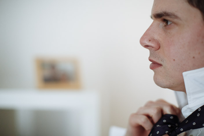 A polka-dot navy tie is worked into its knot in profile