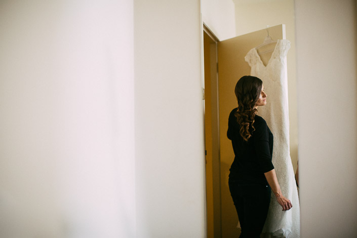 Pascale stands beside her hanging lace wedding gown at Quest on William.