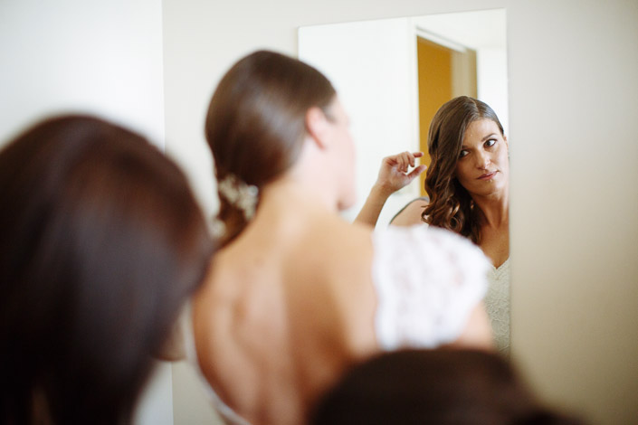 Pascale checks her side-swept hair in a mirror during bridal preparations.