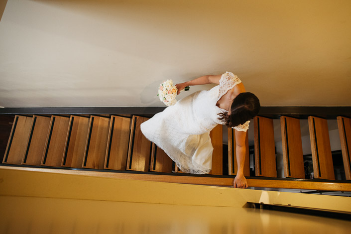 Overhead view of Pascale carrying her bouquet down the timber stairs at Quest on William.