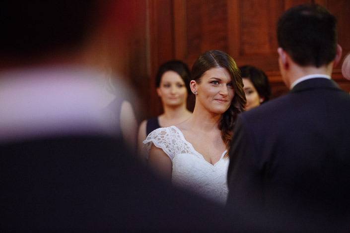 The bride's steady look at the groom between the blurred heads of the front row.