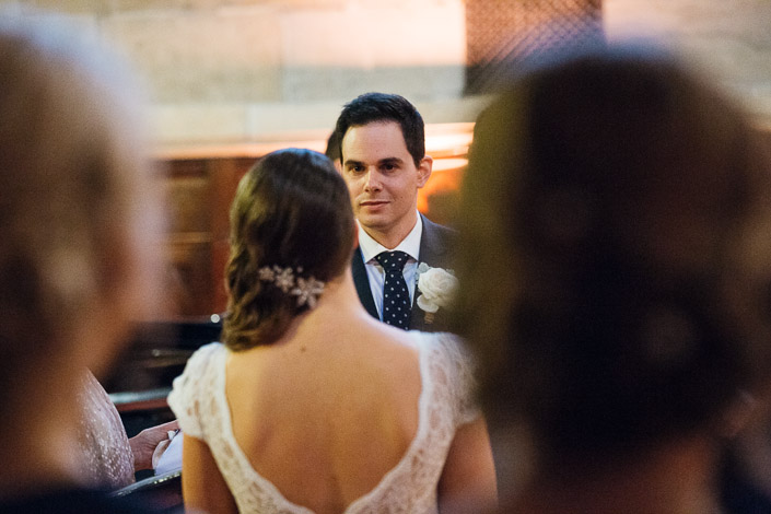 The groom looks towards the bride during their wedding ceremony.