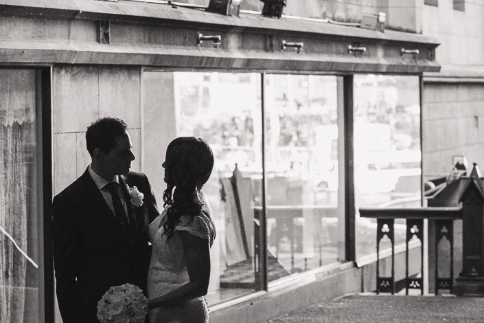 Black-and-white portrait of Pascale and Pasquale beside reflective windows at Chapter House.