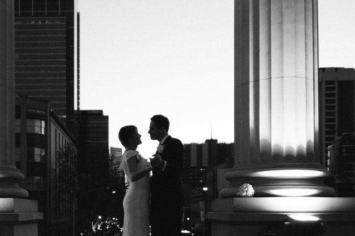 Black-and-white portrait of Pascale and Pasquale beside illuminated columns at Parliament House of Victoria.