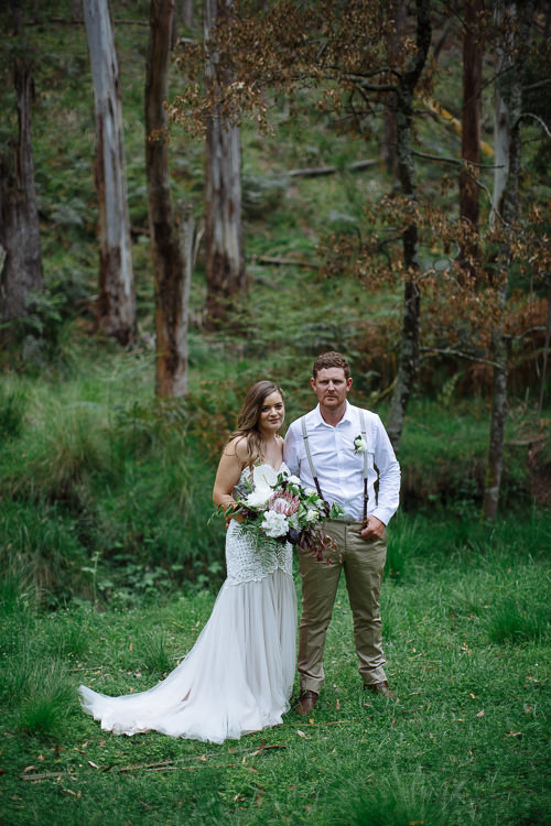 In a fern floored clearing beneath tall mountain ash, Elysha and Mitch stand with the bouquet.
