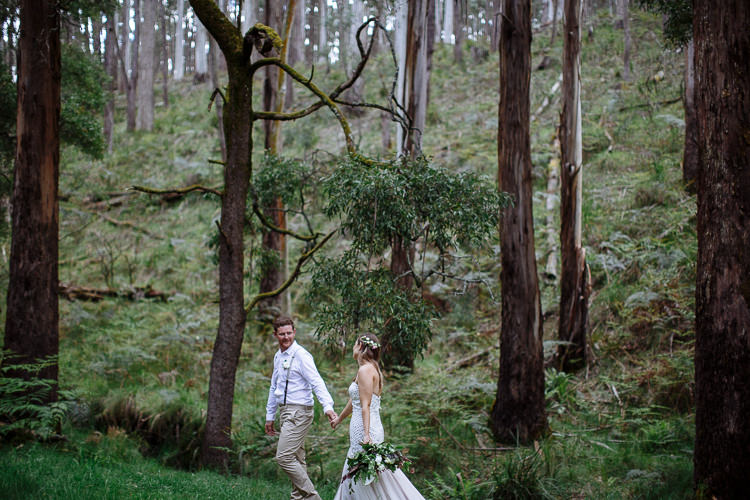 Tiny among mossy trunks and ferns, Mitch leads Elysha by the hand across the forest floor.