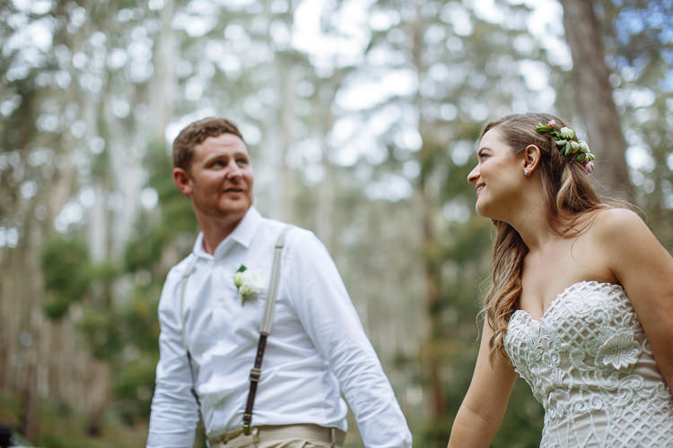 Mitch looks across at Elysha, who smiles back with roses in her hair among pale trunks.