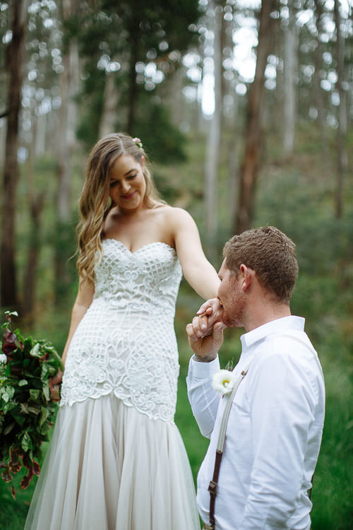Kneeling before Elysha in her beaded gown, Mitch kisses her hand.