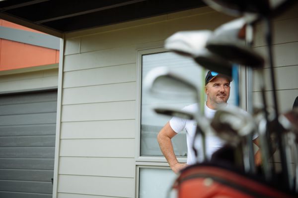 Groom sharing a laugh beside his golf bag on the wedding morning