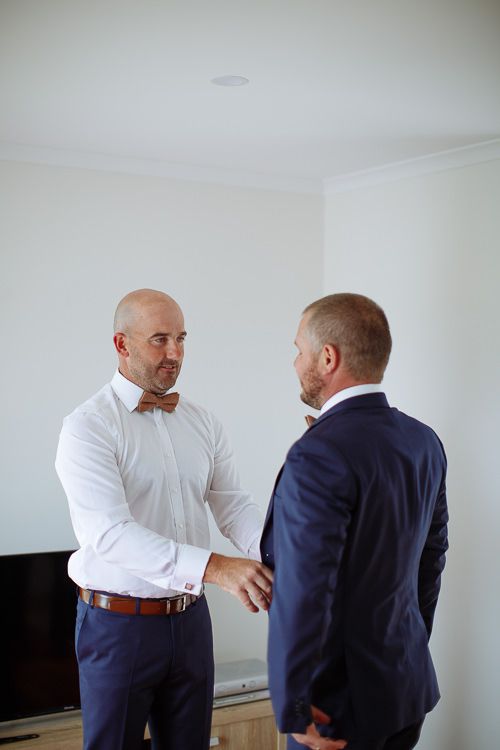 Groom and best man sharing a quiet word while getting dressed
