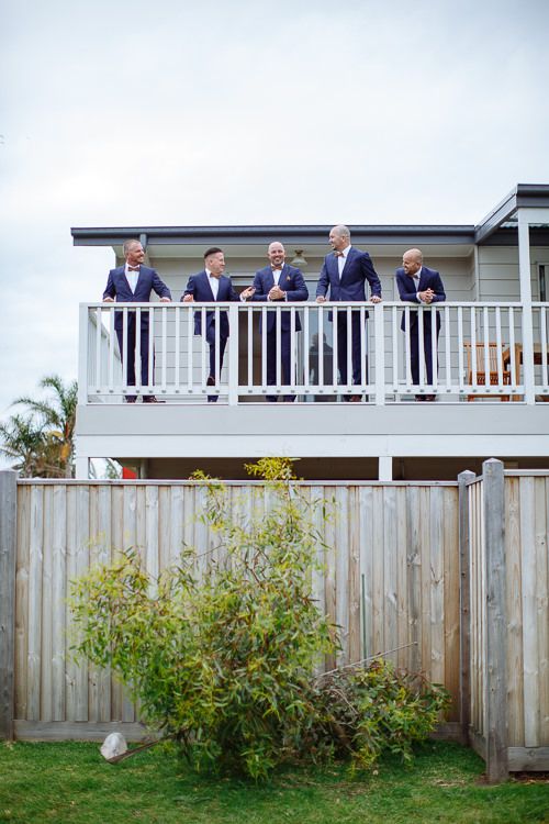 Groomsmen raising a toast from the balcony before the ceremony