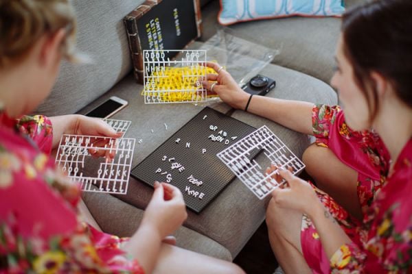 Bridesmaids arranging letter-board signs during the bridal morning