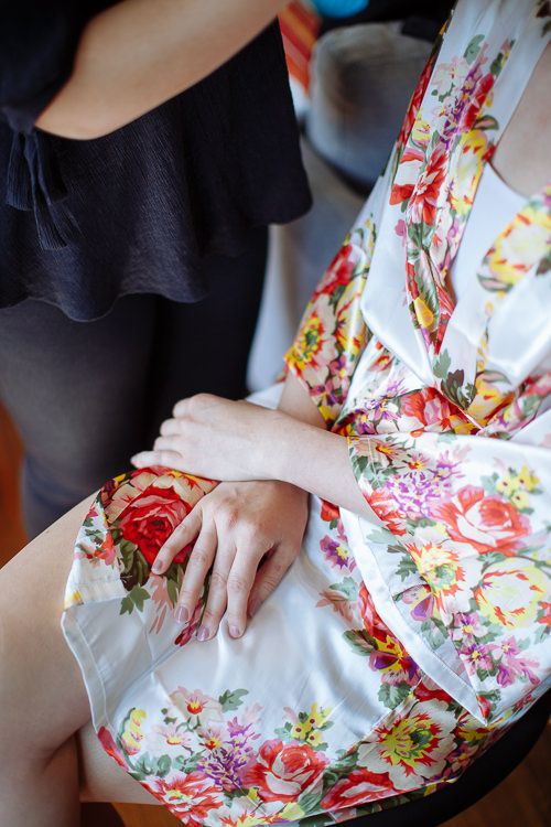 Bridesmaids in floral robes during wedding-morning preparations