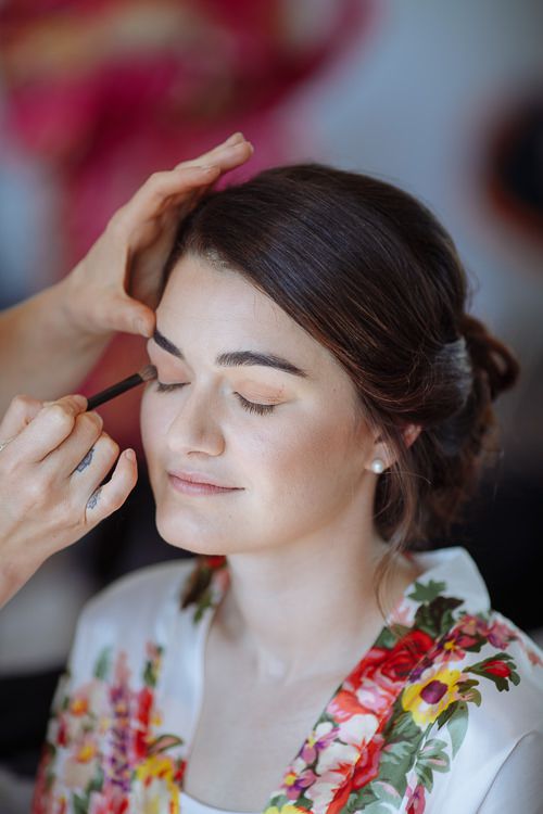 Makeup artist working on the bride's eyes during preparations