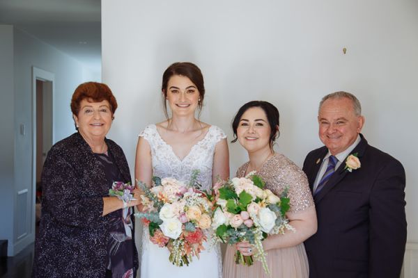 Bride with her grandparents and bridesmaid holding bouquets