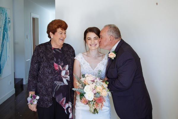 Grandfather kissing the bride on the cheek before the ceremony