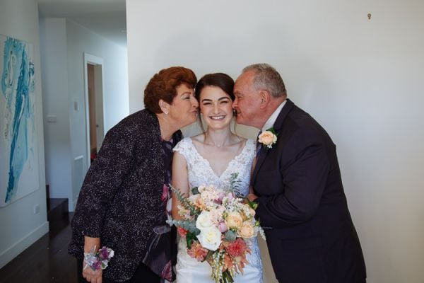Bride embraced by her grandparents – candid family moment
