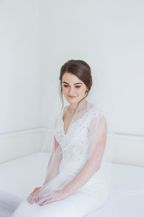 Seated bridal portrait in lace gown and veil before the first look