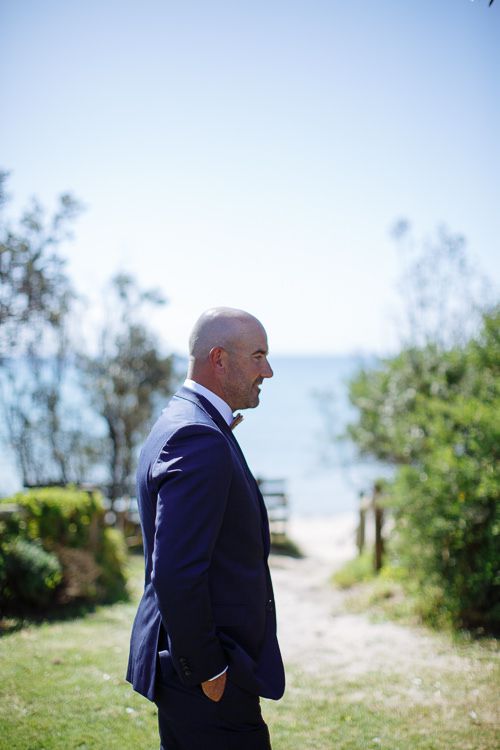 Groom waiting by the beach path for the first look, Port Phillip Bay behind