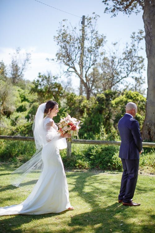 The moment before the first look – veil catching the sea breeze