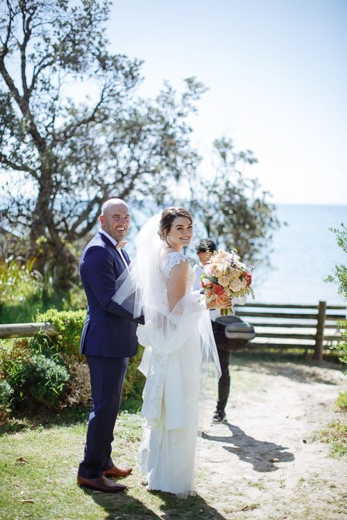 Bride and groom all smiles on the coastal path before the ceremony