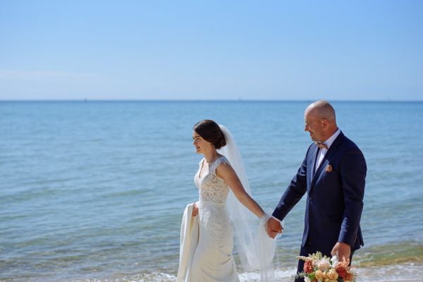 Couple walking beside the calm water of Port Phillip Bay