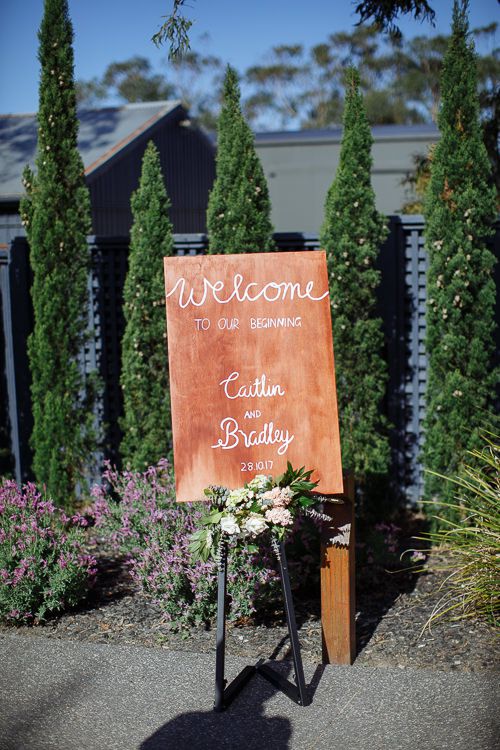 Copper welcome sign for Caitlin and Bradley among the cypress trees