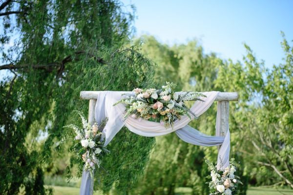 The ceremony arch beneath the willow, Crittenden Estate lake behind